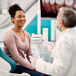 dentist holding a dental implant model