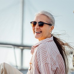 Senior woman in striped shirt on boat smiling