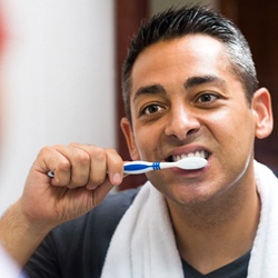 Man brushing his dental implants in Sagamore Hills