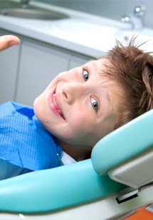 child giving thumbs up in dental chair