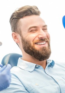 patient smiling while sitting in dental chair