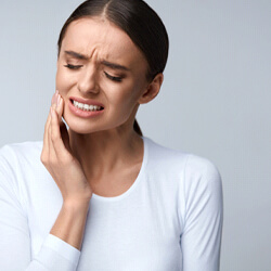 Woman touching her jaw in pain