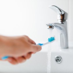 Rinsing off a toothbrush in the sink