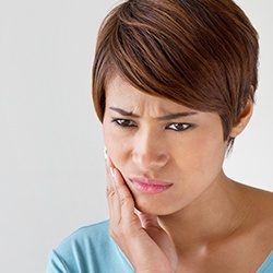 Woman holding jaw in pain