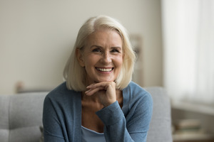 Senior woman sitting on a couch and smiling