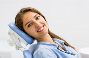 Female patient in dental chair looking back and smiling
