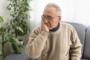 Older man in sweater with tooth pain